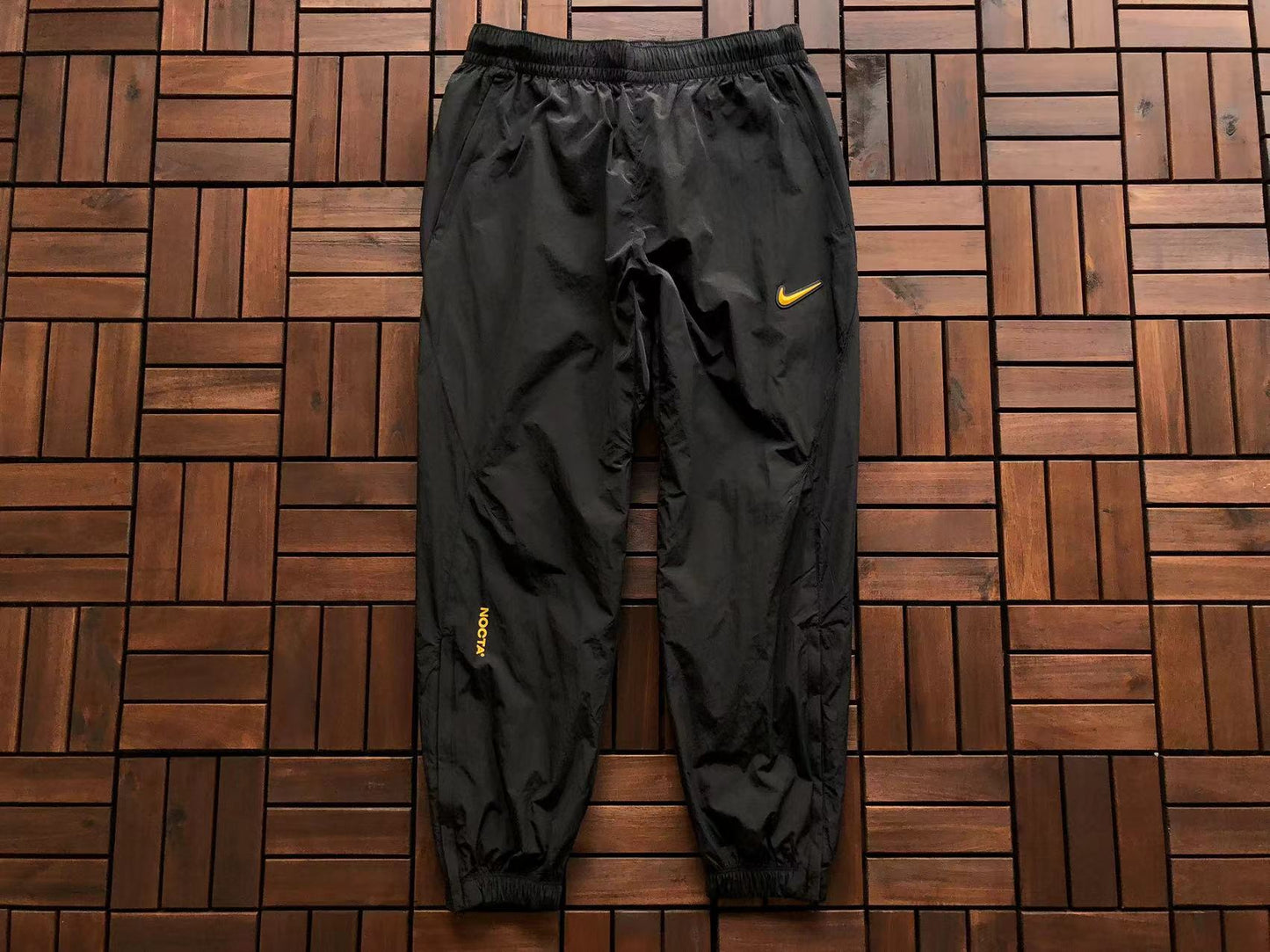 Calça Nike x NOCTA Woven Track Preta/Amarela